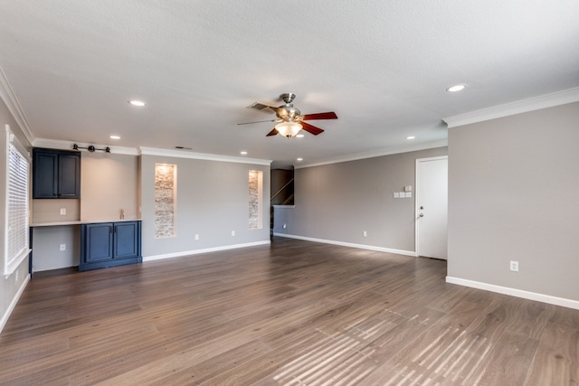 unfurnished living room with crown molding, ceiling fan, and dark hardwood / wood-style floors