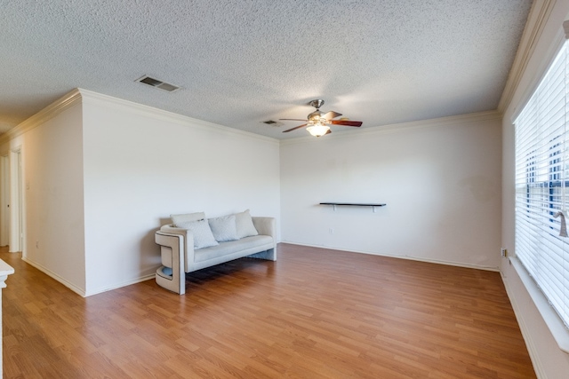 sitting room featuring ceiling fan, ornamental molding, a textured ceiling, and light wood-type flooring