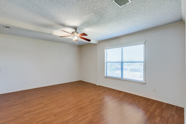 spare room featuring crown molding, a textured ceiling, and hardwood / wood-style flooring