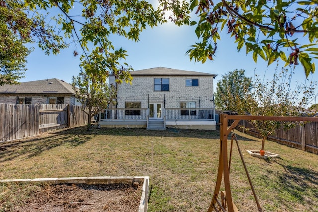 back of house with a yard, a wooden deck, and french doors