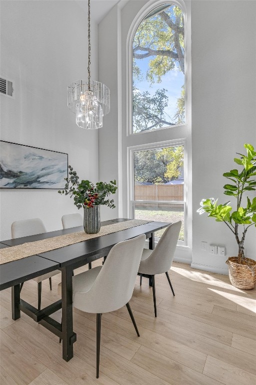 dining room featuring light hardwood / wood-style flooring and a high ceiling