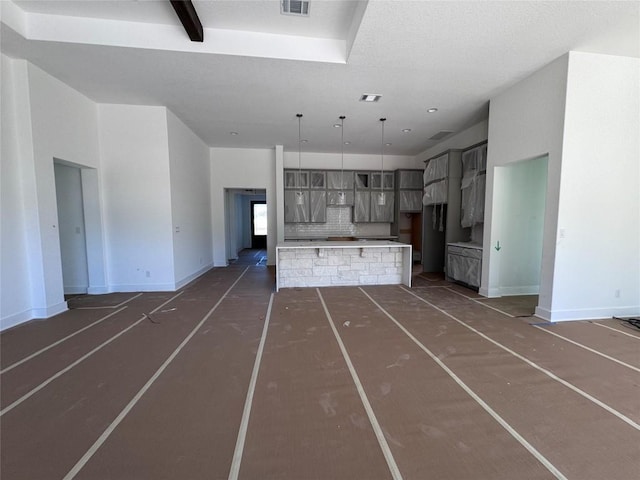 unfurnished living room featuring a high ceiling