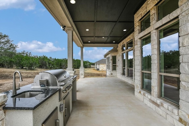 view of patio featuring an outdoor kitchen, sink, and grilling area