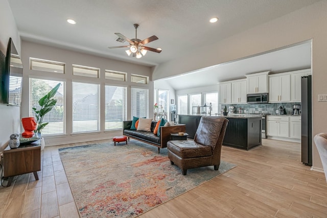 living room featuring light hardwood / wood-style flooring, plenty of natural light, and ceiling fan