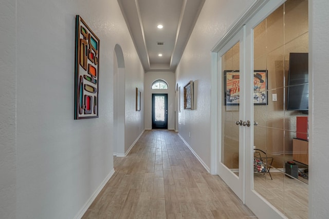 hallway featuring light wood-type flooring and french doors