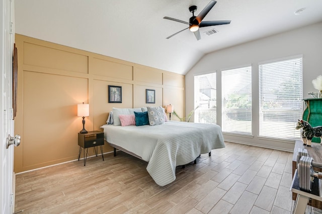 bedroom with ceiling fan, light wood-type flooring, and vaulted ceiling