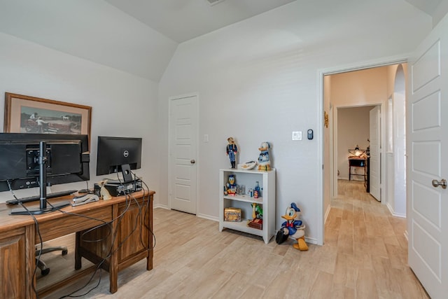 office area with light hardwood / wood-style floors and lofted ceiling