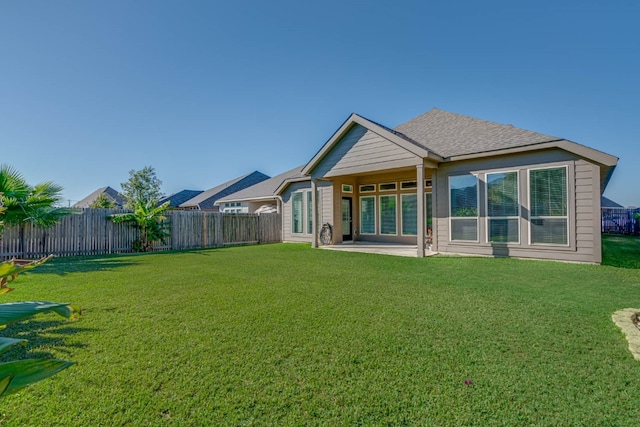 rear view of property with a yard and a patio area