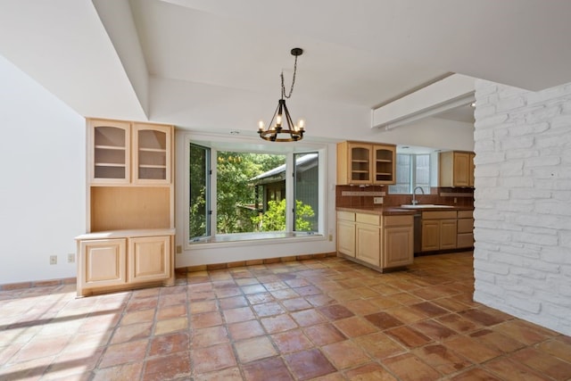 kitchen with sink, light brown cabinets, hanging light fixtures, an inviting chandelier, and tasteful backsplash