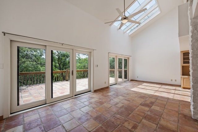 interior space with a healthy amount of sunlight, a skylight, high vaulted ceiling, and french doors