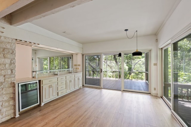 interior space featuring beam ceiling, sink, and beverage cooler