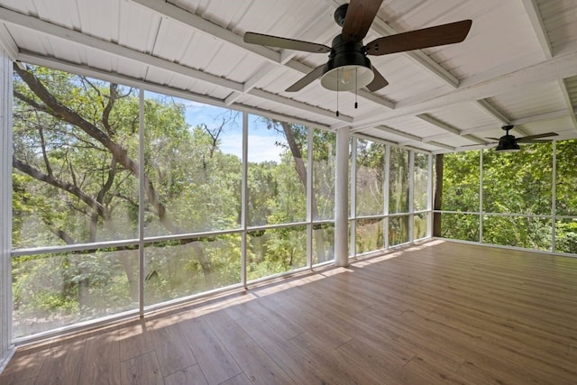 unfurnished sunroom with ceiling fan, beamed ceiling, a healthy amount of sunlight, and wooden ceiling