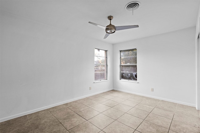 tiled spare room with ceiling fan