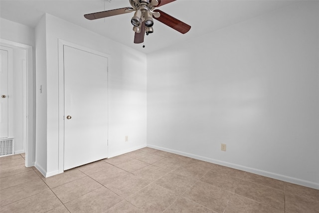 tiled spare room with ceiling fan