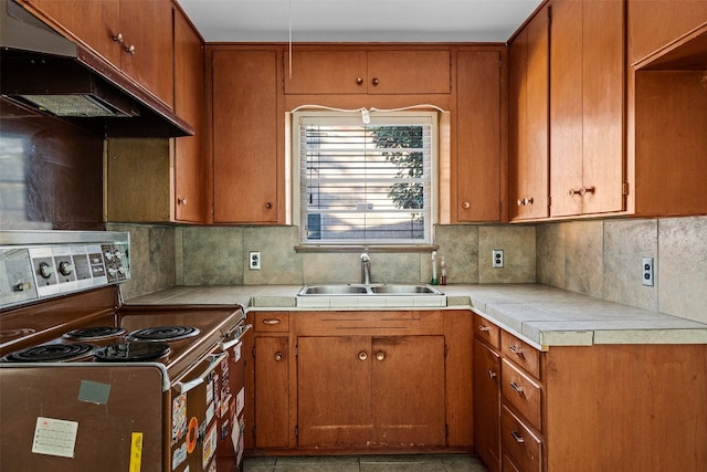 kitchen featuring tile countertops, electric stove, sink, decorative backsplash, and light tile patterned flooring