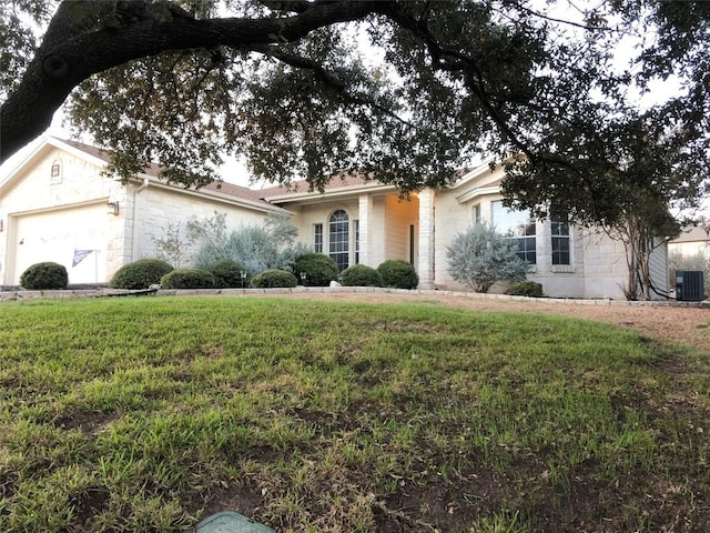 3704 Bunyan Cir, Lago Vista, TX 78645 - view of front of property with a front yard, stone siding, and an attached garage