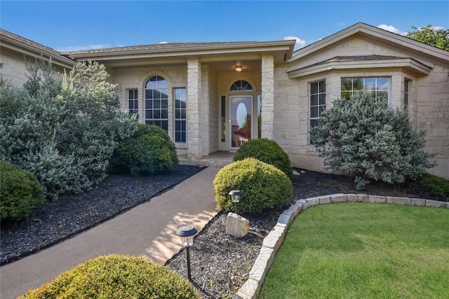 3704 Bunyan Cir, Lago Vista, TX 78645 - view of exterior entry with stone siding and a yard