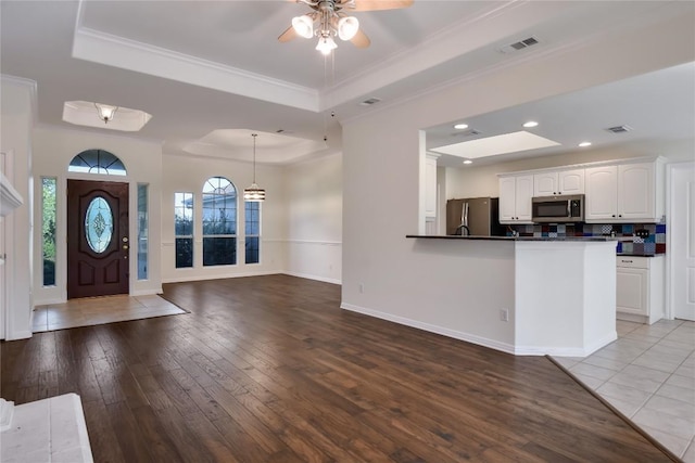 3704 Bunyan Cir, Lago Vista, TX 78645 - entrance foyer with a tray ceiling, a ceiling fan, crown molding, wood-type flooring, and recessed lighting