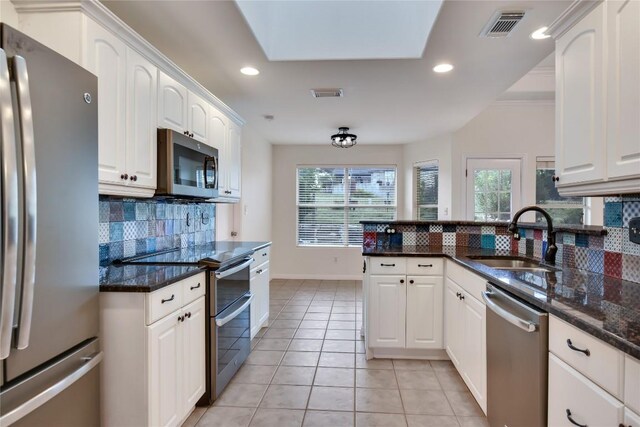 3704 Bunyan Cir, Lago Vista, TX 78645 - kitchen featuring appliances with stainless steel finishes, light tile patterned flooring, backsplash, white cabinetry, and recessed lighting