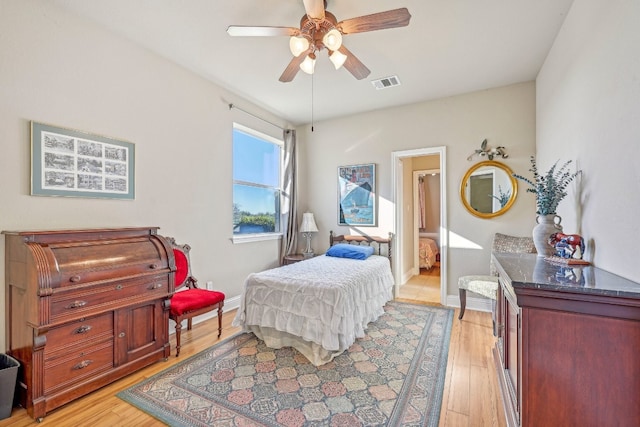 bedroom with ceiling fan, light wood-type flooring, and ensuite bath