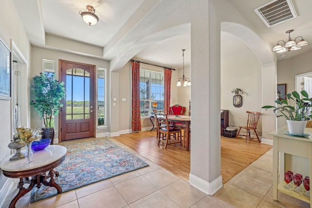 entryway with light hardwood / wood-style floors and a chandelier