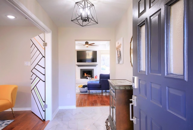 entryway featuring ceiling fan with notable chandelier and light wood-type flooring