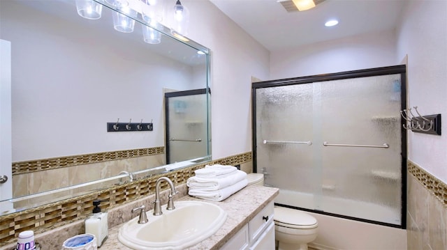 full bathroom featuring shower / bath combination with glass door, vanity, backsplash, and toilet