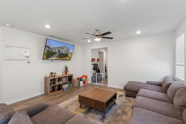 living room featuring a ceiling fan, visible vents, wood finished floors, baseboards, and recessed lighting