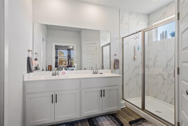 bathroom featuring vanity, wood-type flooring, and a shower with shower door