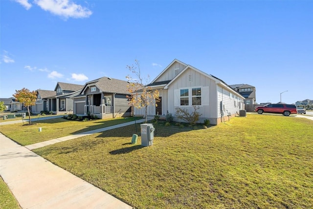 view of front of house featuring central AC unit, board and batten siding, and a front yard