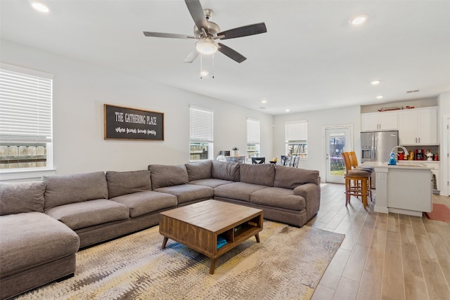 living area featuring a ceiling fan, recessed lighting, and light wood finished floors