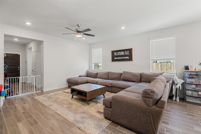 living room featuring ceiling fan, hardwood / wood-style floors, and plenty of natural light