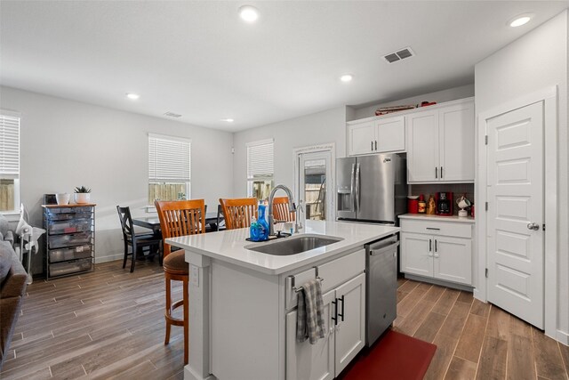 kitchen featuring white cabinets, sink, an island with sink, and stainless steel appliances