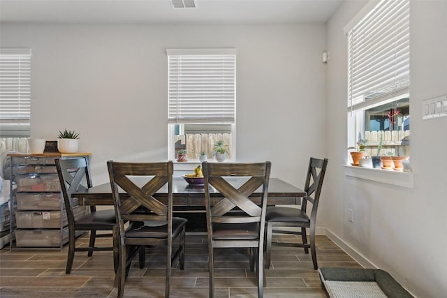 dining space featuring baseboards, visible vents, and wood finish floors