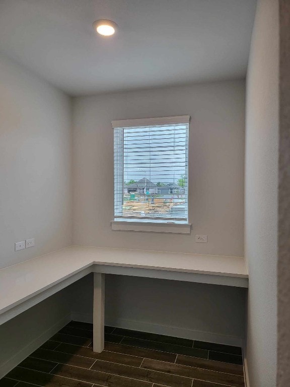 interior space with dark hardwood / wood-style flooring and built in desk