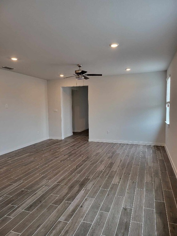 unfurnished room featuring dark hardwood / wood-style floors and ceiling fan