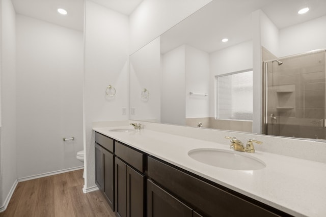 bathroom with vanity, hardwood / wood-style flooring, toilet, and an enclosed shower