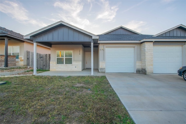 view of front of house featuring covered porch, a garage, and a front yard