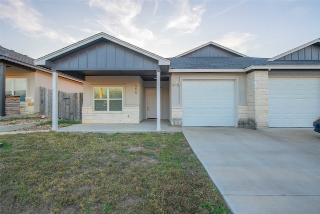 view of front facade featuring covered porch, a garage, and a front lawn