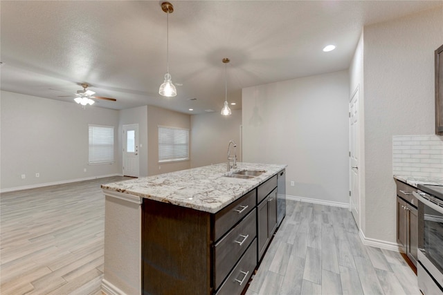 kitchen featuring pendant lighting, light wood-type flooring, dark brown cabinets, and sink