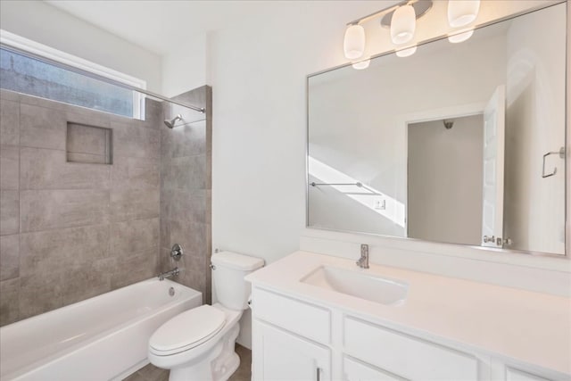 full bathroom with tiled shower / bath, vanity, and toilet