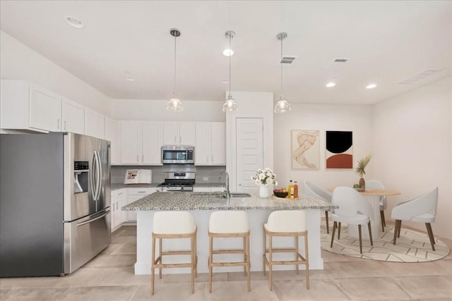 8922 Menchaca Rd Unit 906, Austin, TX 78748 - kitchen with stainless steel appliances, white cabinetry, light tile patterned floors, light stone countertops, and recessed lighting
