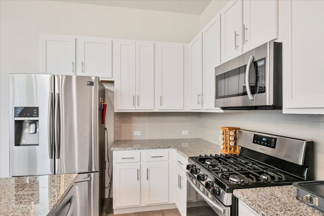 kitchen featuring backsplash, stainless steel appliances, and white cabinets