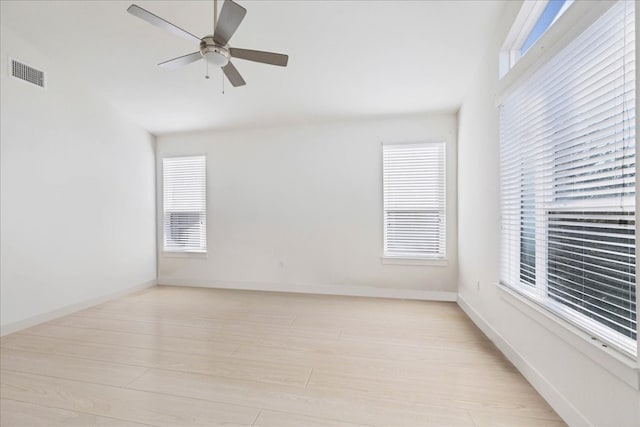 unfurnished room with ceiling fan, a wealth of natural light, and light hardwood / wood-style floors