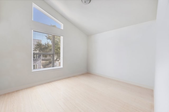 unfurnished room with lofted ceiling and light wood-type flooring