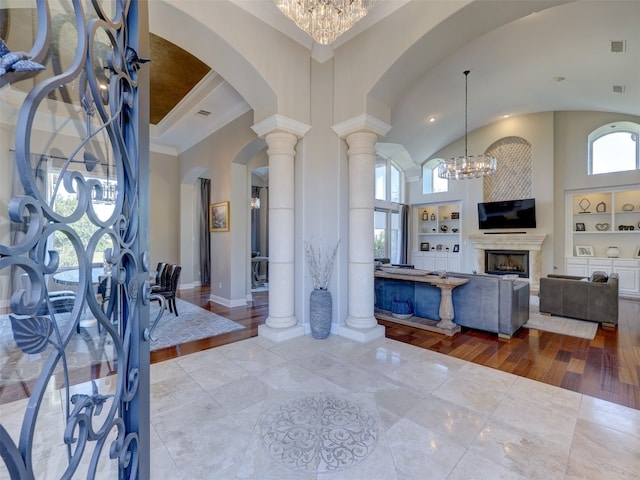 foyer entrance featuring a notable chandelier, light hardwood / wood-style floors, and a high ceiling