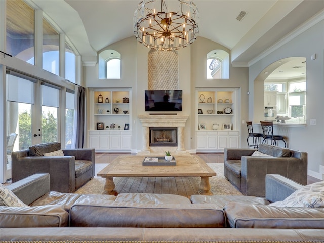 living room featuring built in shelves, a healthy amount of sunlight, and a chandelier