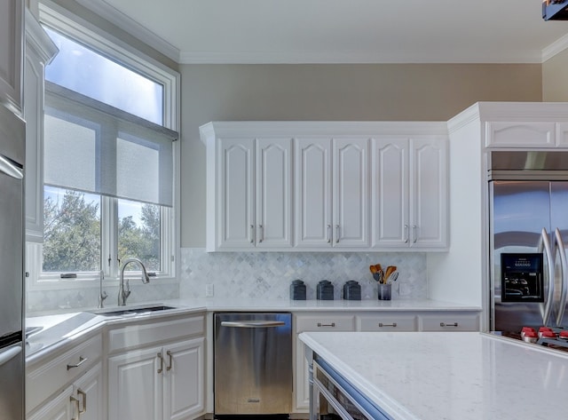 kitchen with backsplash, white cabinets, stainless steel appliances, and ornamental molding