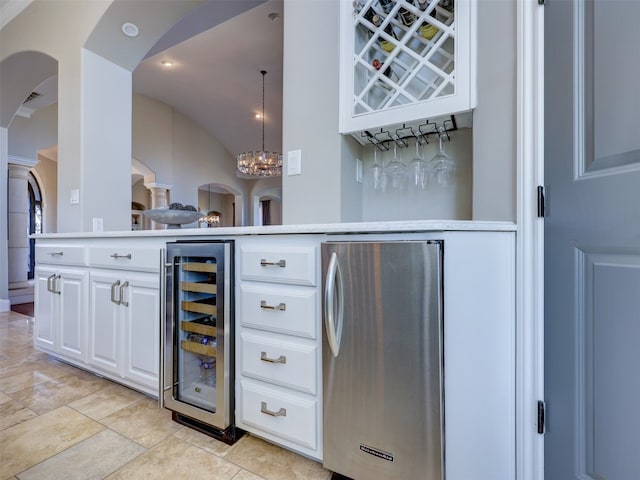 bar featuring pendant lighting, white cabinets, wine cooler, vaulted ceiling, and stainless steel refrigerator