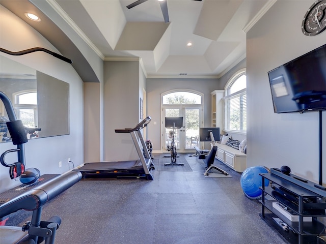 workout room with a tray ceiling and crown molding